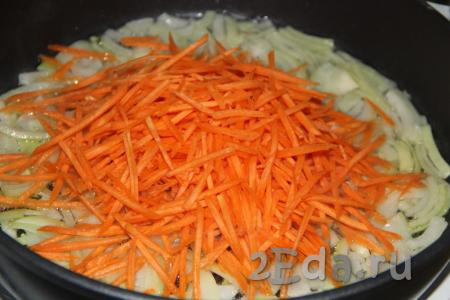 Затем к луку выложить очищенную морковку, натёртую на крупной тёрке (я использовала тёрку для моркови по-корейски).