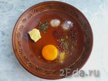 В миску выложить яйцо, соль, соду, специи и размягчённое сливочное масло (для того чтобы масло размягчилось, его нужно заранее достать из холодильника), перемешать.