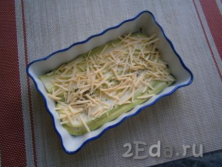 Посыпать слой кабачков частью натёртого сыра.