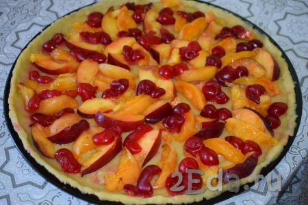 На тесто выкладываем дольки фруктов и раскладываем ягоды по всему периметру пирога. Присыпаем пирог сахаром.