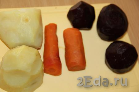 Картофель, морковь и свеклу сварить в кожуре до готовности и остудить. Свекла обычно варится, примерно, 45-60 минут (в зависимости от размера корнеплода) с начала кипения воды, а морковь и картофель будут готовы через 20-25 минут. Почистить варёные морковь, свеклу и картошку. При желании, можно овощи не отваривать, а  запечь в фольге в духовке.