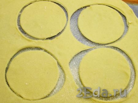 Для удобства делим тесто на несколько частей, доску для раскатывания теста посыпаем мукой и тонко раскатываем тесто. Его толщина не должна быть более 1 мм. Стаканом (или круглой формочкой) вырезаем кружочки диаметром, примерно, 6-7 см.