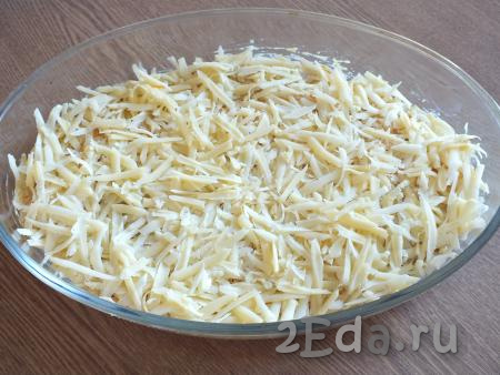 Натрите сыр на крупной тёрке и равномерно разложите поверх сметанного соуса. Поставьте форму с минтаем под соусом в разогретую до 180 градусов духовку и запекайте минут 25-30.