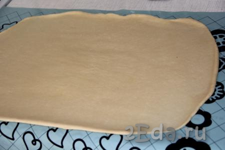 Раскатать тесто скалкой в пласт прямоугольной формы длиной, примерно, 60 см.