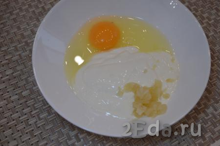 В отдельную посуду добавить 1 сырое яйцо, 2 пропущенных через пресс зубчика чеснока, 3-4 столовых ложки сметаны.