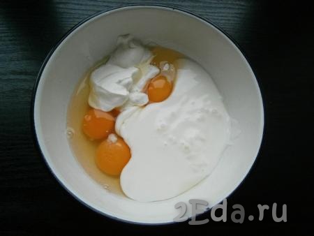 В отдельную ёмкость к сырым яйцам добавить кефир и сметану.