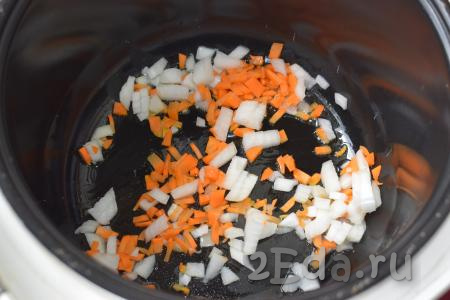 Морковь и лук очищаем от кожицы и нарезаем на мелкие кубики. Ставим мультиварку на режим "Жарка", вид продукта "Рыба" - при этом режиме жарка длится 15 минут, что нам и нужно. После начала отсчёта времени наливаем в мультиварку растительное масло и добавляем лук с морковью. Обжариваем овощи, постоянно помешивая, не закрывая крышку мультиварки, примерно, 7 минут.