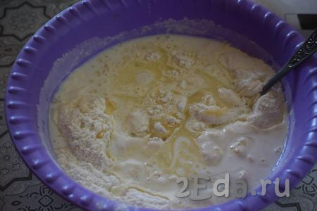 Добавляем в миску растительное масло и начинаем замешивать тесто вначале ложкой, а потом продолжаем замешивать руками.