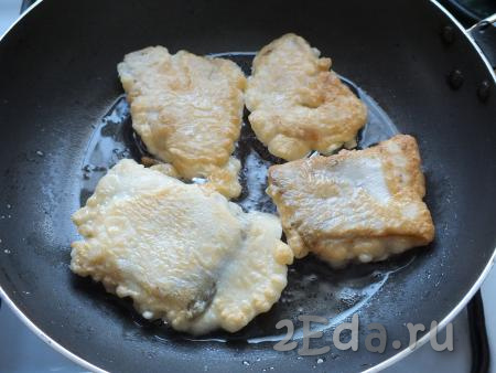 Через указанное время переверните кусочки рыбки на другую сторону, прикройте сковороду крышкой и обжаривайте филе минтая с другой стороны минут 5.