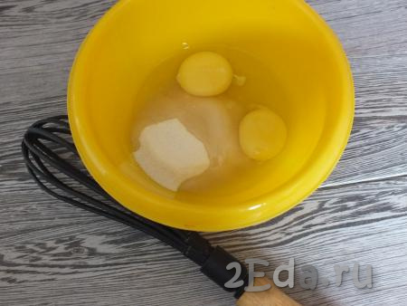 В отдельной миске смешайте венчиком яйца и сахар.