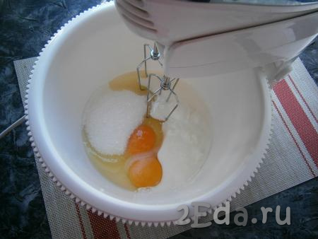 Я замешивала тесто миксером (можно, несомненно, замесить и в глубокой миске с помощью ложки). В чашу миксера (или в глубокую миску) поместить яйца, оставшийся сахар, соль, ванильный сахар, добавить йогурт комнатной температуры. Йогурт можно заменить на кефир или ряженку.