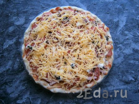 По желанию, смазать помидоры немного майонезом и посыпать пиццу натёртым на средней (или мелкой) тёрке сыром.