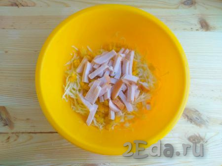 Ветчину нарезать тонкими брусочками и выложить в салат из капусты и кукурузы, перемешать.