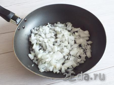 Репчатый лук очистите, нарежьте на мелкие кубики и обжарьте до мягкости на сковороде на среднем огне с добавлением 2 столовых ложек растительного масла (на это уйдёт минут 5).