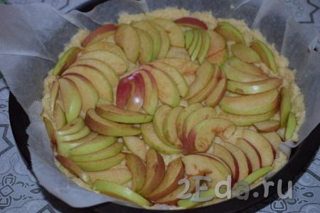 Далее раскладываем яблочные дольки по всему периметру пирога.