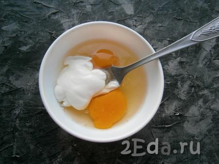 К яйцам добавить сметану и немного соли.