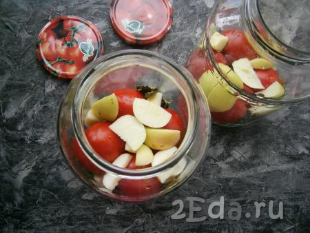 Яблоки вымыть, удалить сердцевину и нарезать дольками. Банки наполнить помидорами, перекладывая их яблоками.