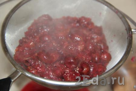 Небольшими порциями выложить ягоды на сито и перетереть мякоть в кастрюлю. Жмых и корочки цитрусовых, оставшиеся в сите, выкинуть.