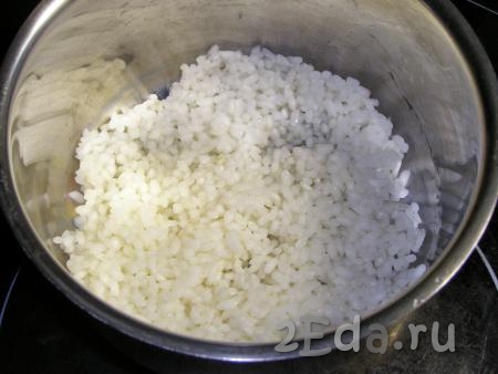 В слегка подсоленную кипящую воду выкладываем промытый рис, даём закипеть и, уменьшив огонь, отвариваем до полуготовности (то есть зёрна должны быть мягкими снаружи, но твёрдыми внутри - на это потребуется 10-15 минут). Откидываем рис на дуршлаг и оставляем, чтобы стекла вода и рис остыл (промывать отваренный рис не надо).