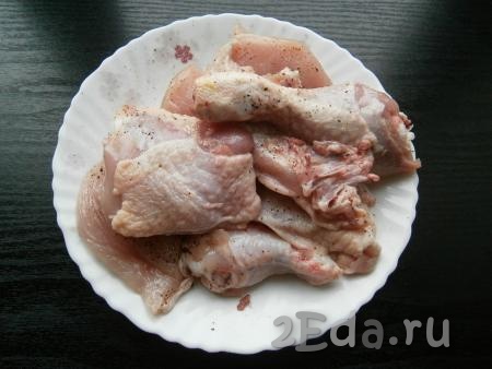Посолить кусочки курицы, посыпать молотым перцем и специями.