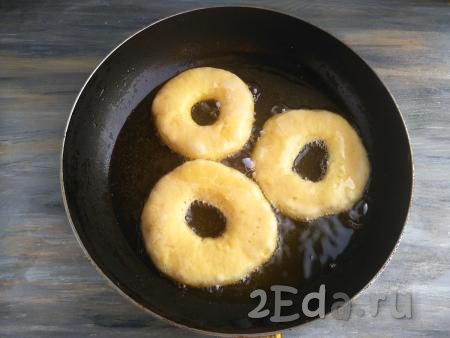 В сковороду влить растительное масло, разогреть его. Выложить заготовки пончиков в горячее масло.