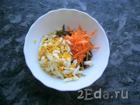 Сырую морковку очистить и натереть на крупной тёрке, яйца нарезать длинными кусочками. Добавить морковку и яйца к морской капусте.