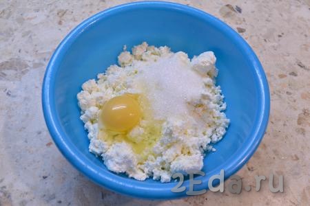 Изюм замочить в кипятке на 10 минут, затем воду слить, а изюм обсушить. К творогу добавить соль, сырое куриное яйцо и всыпать сахар.