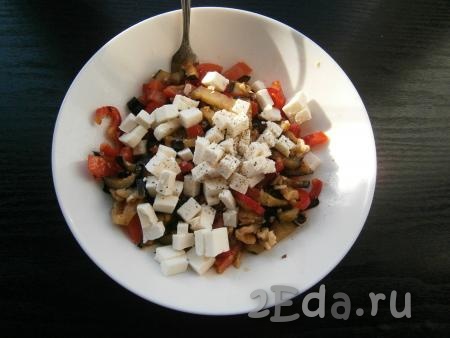 Брынзу нарезать небольшими кубиками и добавить ее к остальным ингредиентам,  поперчить салат с баклажанами.
