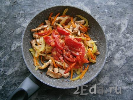 Соединить овощи с обжаренной свининой в сковороде, добавить нарезанные дольками свежие помидоры, поперчить, влить соус-маринад.