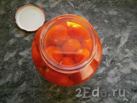 Заполнить банку небольшими помидорами, не слишком плотно. Залить помидоры крутым кипятком, прикрыть крышкой и оставить на 20 минут.
