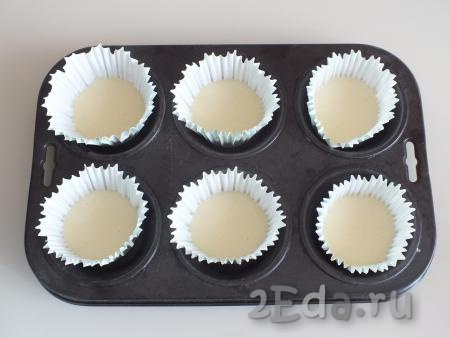 Формы для кексов смажьте маслом (или используйте бумажные вкладыши), разлейте тесто, заполняя формочки на 1/2 объёма.