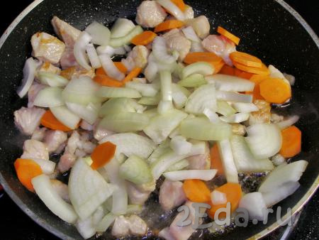 Добавляем в сковородку к мясу нарезанные лук и морковь, перемешиваем и обжариваем на среднем огне, периодически помешивая, пока лук и морковь не станут мягкими.