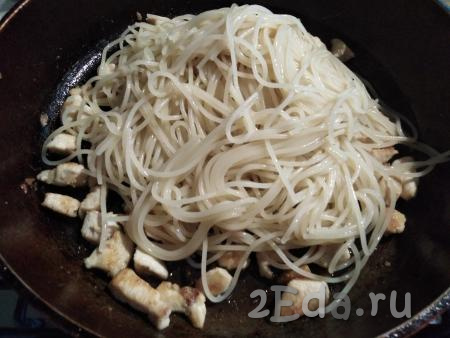 Готовые спагетти выкладываем на сито, чтобы стекла вода. А затем сразу, не промывая, горячие спагетти выкладываем в сковородку к курице с чесноком. 