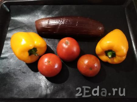 Через 20 минут открываем духовку и к баклажану выкладываем болгарские перцы и помидоры, ставим в духовку и запекаем все овощи в течение 20 минут при той же температуре.