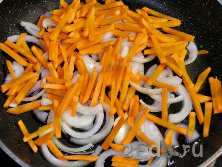 В сковородку наливаем 1 столовую ложку подсолнечного масла, выкладываем в него лук и морковь, обжариваем на среднем огне минуты 3, помешивая, пока овощи не станут мягкими.