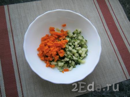 Свежий огурец и очищенную варёную морковку нарезать небольшими кубиками и выложить в миску.