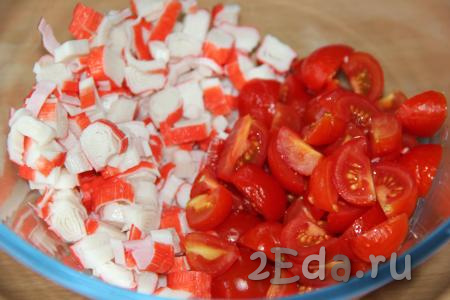 Вымыть помидоры и нарезать (помидорчики черри нужно разрезать пополам, если будете использовать более крупные помидоры, тогда  разрежьте их на несколько частей). В салатнике соединить нарезанные крабовые палочки и помидоры.