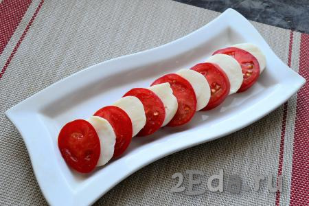 Помидоры выбирайте приблизительно такого же диаметра, как и моцарелла. Их тоже нужно нарезать кружочками. На блюдо (или на тарелку) выкладывать сыр и помидоры, чередуя их между собой.