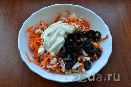 Маслины, нарезанные колечками, и майонез добавить в салат с корейской морковкой, яйцами и крабовыми палочками.