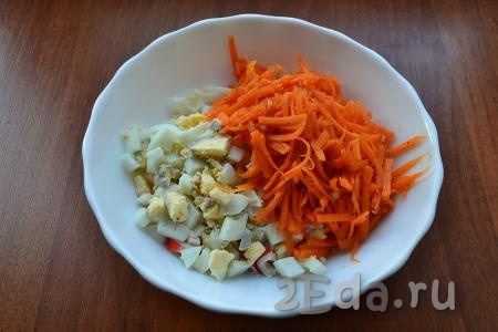 Добавить корейскую морковь, немного измельченную ножом, а также нарезанные вареные яйца.
