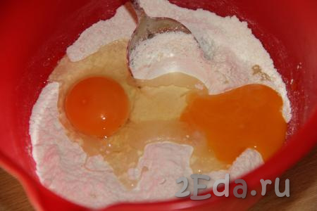 В получившуюся мучную смесь добавить яйцо и яичный желток.