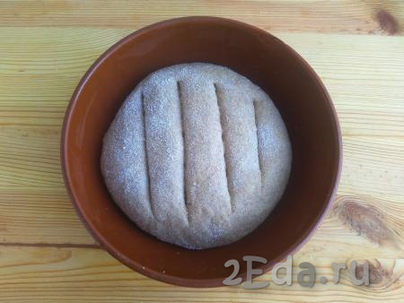 Придать тесту округлую форму, обвалять в пшеничной муке, сделать сверху надрезы. Выложить в форму для выпечки.