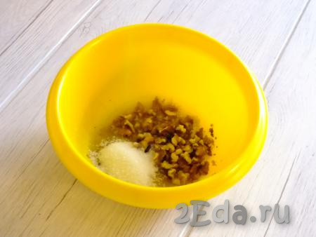 В масляно-медовую массу добавьте дроблёные грецкие орехи и сахар, перемешайте и поставьте в микроволновую печь ещё на 10 секунд. Достаньте медово-ореховую массу и перемешайте.