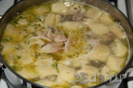 Добавить мясо курицы и чесночные рулетики в бульон. Варить куриный суп ещё 10-15 минут.