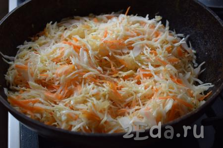 Как только лук станет прозрачным, отправляем к нему капусту с морковью, перемешиваем и тушим на медленном огне, примерно, 10 минут, накрыв сковороду крышкой, иногда перемешивая.