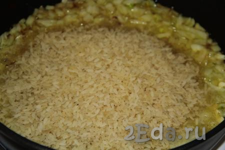 Всыпать рис (я использую пропаренный рис). Обжарить рис с луком на среднем огне, помешивая, в течение 2 минут.