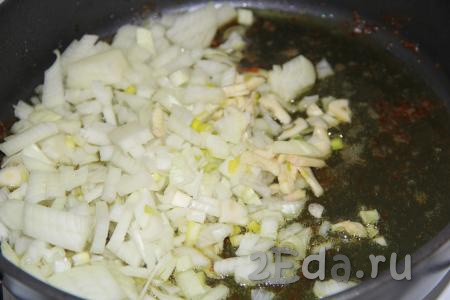 Переложить бёдра на тарелку, а в сковороду с маслом, на котором жарили курицу, выложить очищенные и мелко нарезанные лук и чеснок.