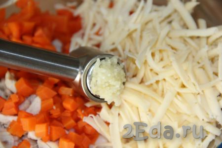 В салат из курицы, яиц и риса добавить сыр, морковь и зубчик чеснока, пропущенный через пресс.