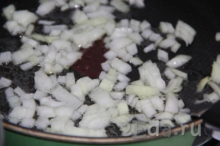 Репчатый лук очистить и мелко нарезать. Выложить лук на сковороду с добавлением растительного масла и обжарить на среднем огне пару минут, помешивая.