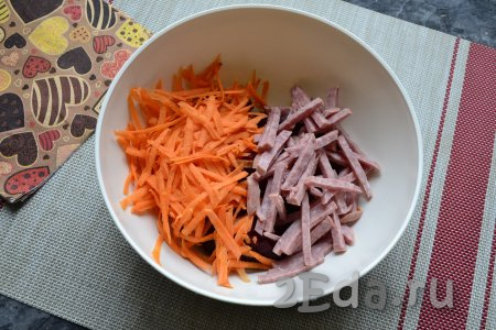 Очистить сырую морковь, а затем натереть на крупной тёрке. Колбасу нарезать брусочками (или соломкой) и вместе с морковкой выложить к свекле.